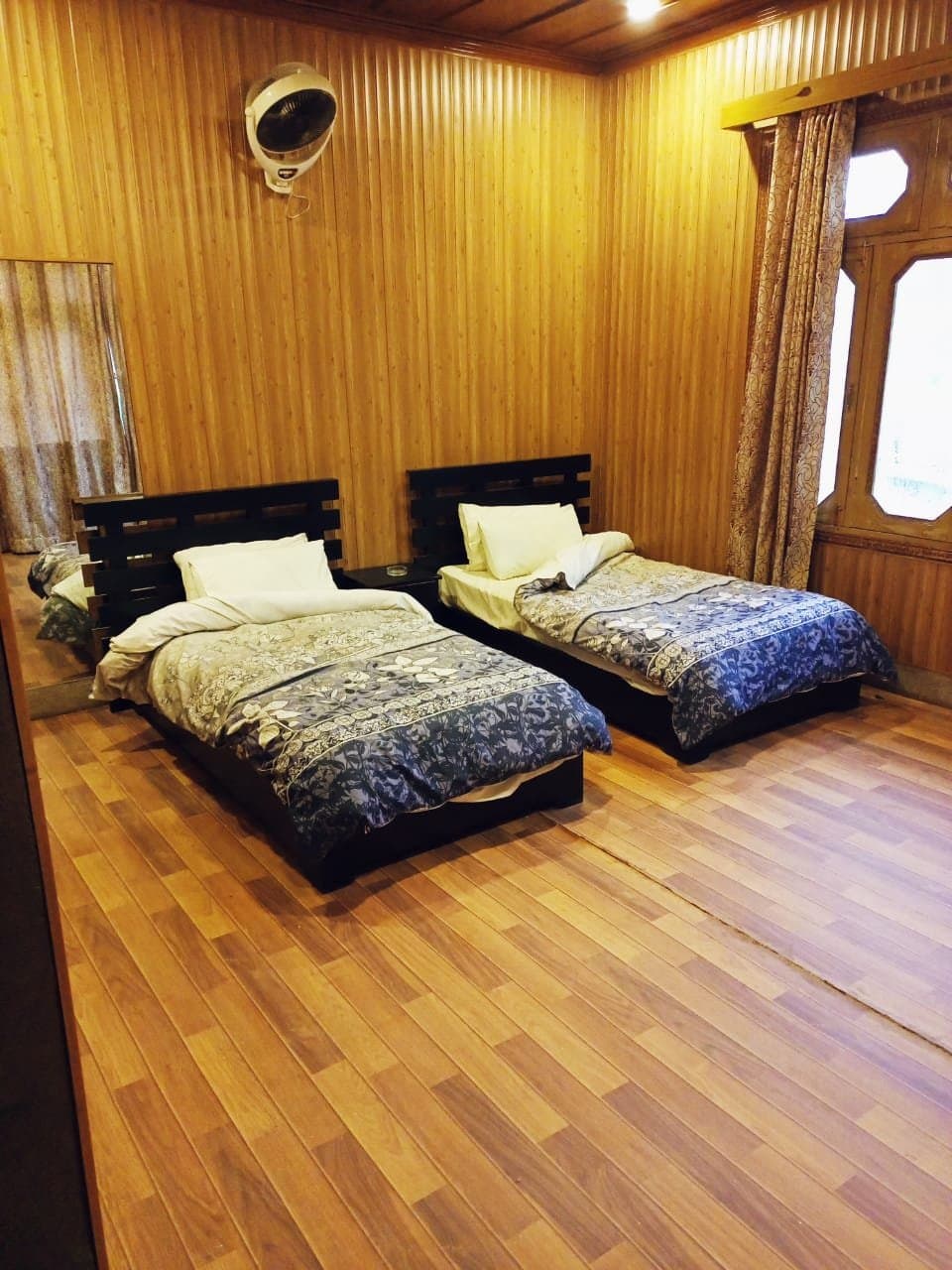Twin bedroom with warm wood-panelled walls